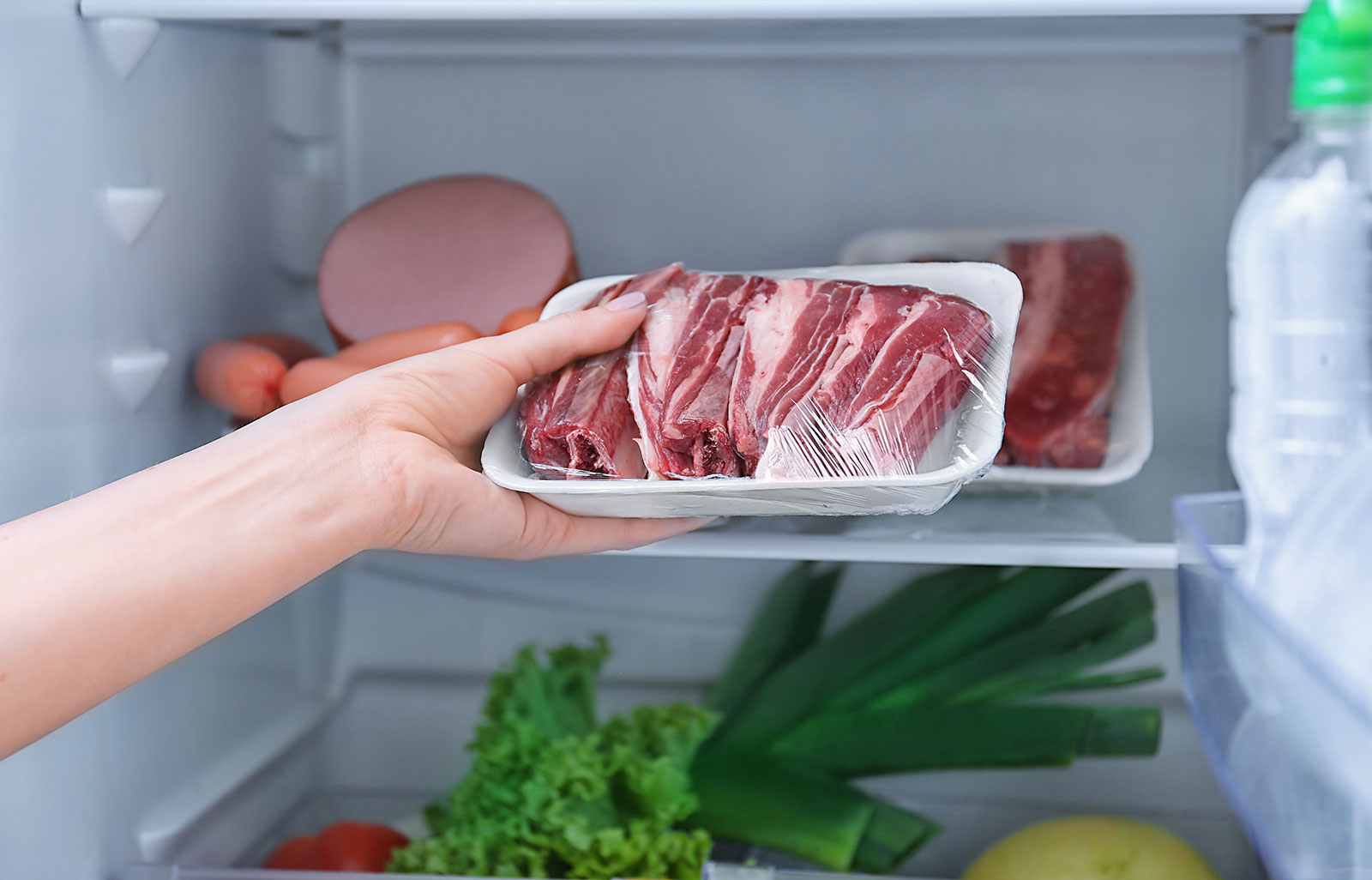 Raw steaks being put in refrigerator