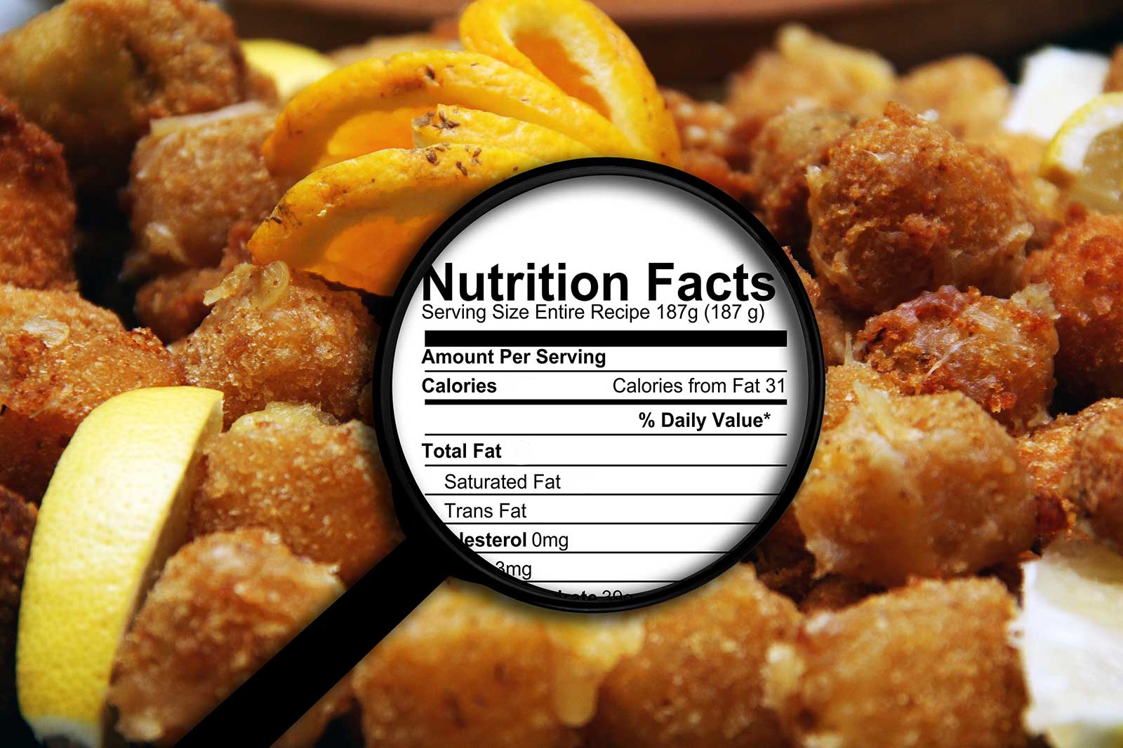 Magnifying glass over nutrition facts overlaying fried food