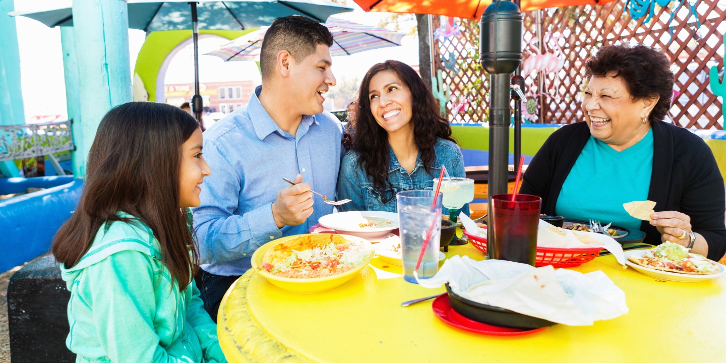 family eating at table outside